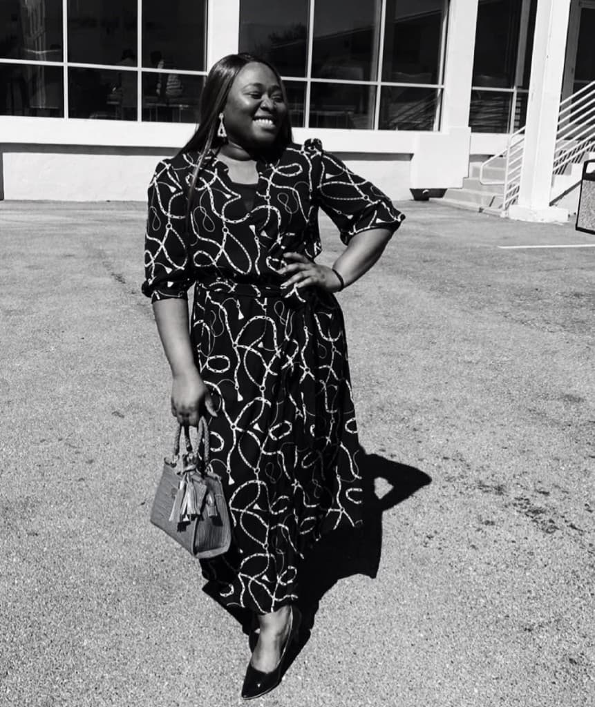 A smiling woman standing outside the church building
