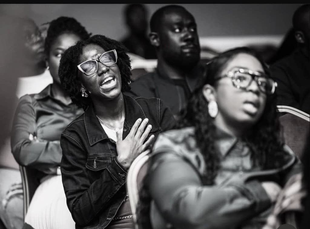 A woman worshiping with her hand over her heart